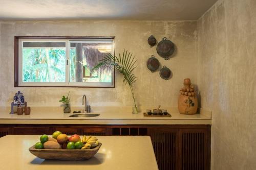 a kitchen with a bowl of fruit on a counter at Olas Tulum in Tulum