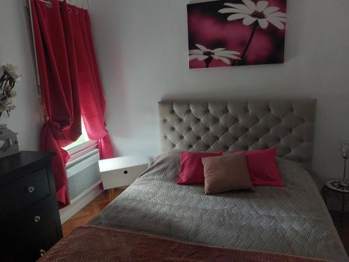 a bedroom with a large bed with red curtains at Chez mimi in Toulouse