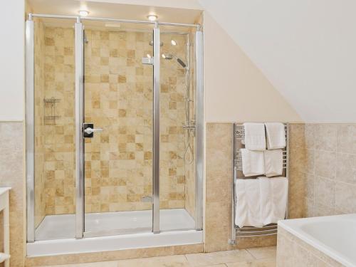 a shower with a glass door in a bathroom at Stockham Lodge in Colyton