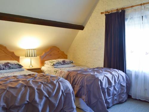 1 dormitorio con 2 camas y ventana en Mill Batch Cottage, en Mark