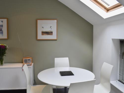 a white dining room with a white table and chairs at Biggan Mews in York