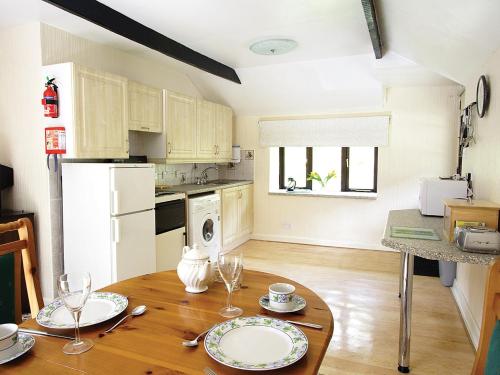 une cuisine avec une table en bois et des plaques de cuisson. dans l'établissement Rosecraddoc Manor - Hayloft, à Saint Cleer