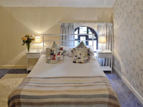Saint CleerにあるRosecraddoc Manor - Hayloftのベッドルーム1室(大型ベッド1台、テーブル2台、窓付)