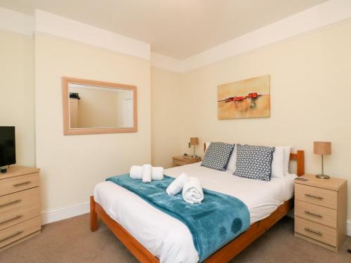 a bedroom with a bed with a mirror and a tv at Louisa Cottage in Weymouth