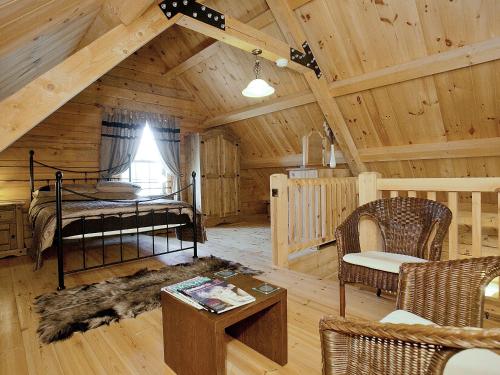 MiningsbyにあるKingfisher Lodge - E4159aのベッドルームとリビングルームが備わるログキャビンです。