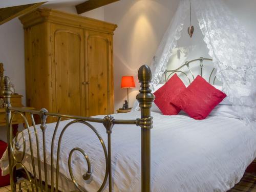 - une chambre avec un lit à baldaquin et des oreillers rouges dans l'établissement The Old Folly, à Hunmanby