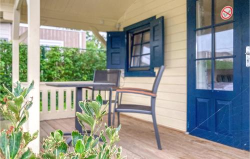 a chair on the porch of a house with a blue door at Awesome Home In Heinkenszand With Wifi in Heinkensand
