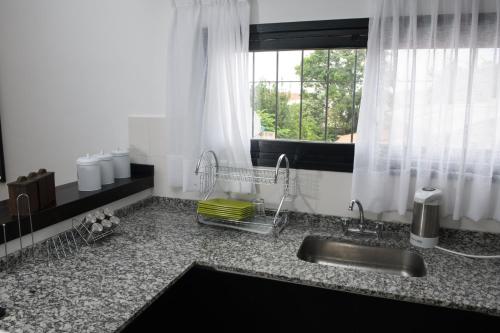 encimera de cocina con fregadero y ventana en Departamento con terraza y quincho con asador en Salta