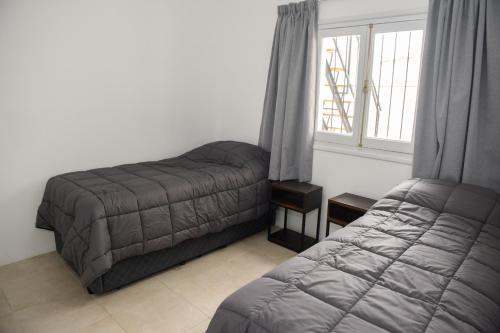 1 dormitorio con cama y ventana en Departamento con terraza y quincho con asador en Salta