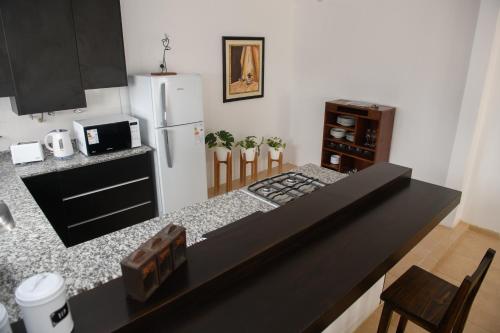 a kitchen with a counter top and a refrigerator at Departamento con terraza y quincho con asador in Salta