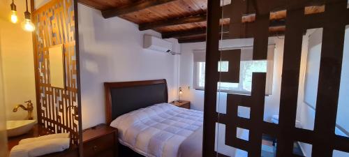 1 dormitorio con 1 cama y baño con lavamanos en EL BOSQUE DE LAS ANIMAS en Tandil