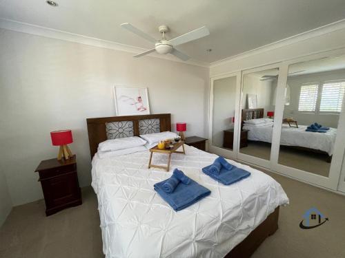 Un dormitorio con una cama grande con almohadas azules. en Harbord House - Ocean views, plunge pool, 2 bed, free-wi-fi, superb location, en Freshwater