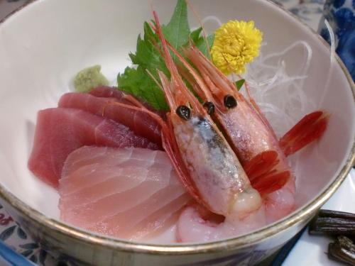 a bowl of food with a fish on top of meat at 池の平温泉 ロッジ コクハ in Myoko