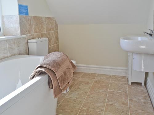 a bathroom with a bath tub and a sink at A Bit On The Side in Chillenden