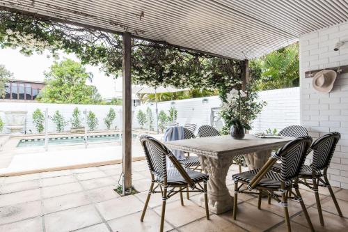 a patio with a table and chairs on a patio at One Marola is stylish privacy in paradise in Noosa Heads