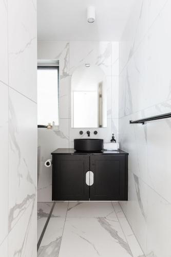 a bathroom with a black sink and a mirror at One Marola is stylish privacy in paradise in Noosa Heads