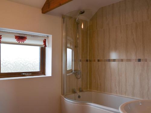 a bathroom with a tub and a sink and a window at Sunrise Barn - E4865 in Chapel Saint Leonards