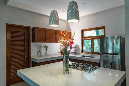 a kitchen with a vase of flowers on a counter at Olas Tulum in Tulum