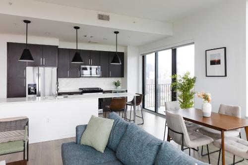 a kitchen and living room with a blue couch and a table at Mint House Houston - Medical Center in Houston