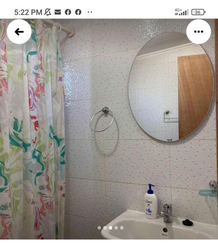 a bathroom with a shower curtain and a sink at cabañas jessy in Valdivia