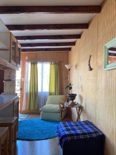 a living room with a bed and a table at cabañas jessy in Valdivia