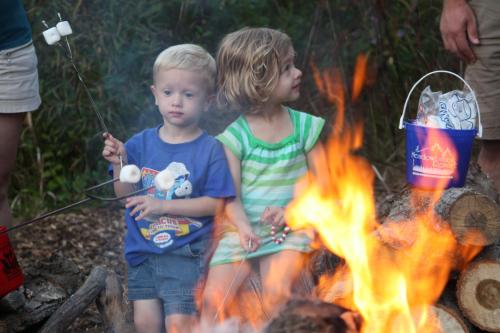 two young children sitting around a fire at Meadowbrook Resort in Wisconsin Dells