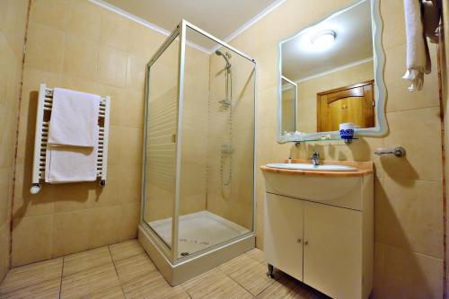 Un baño con ducha, lavabo y espejo. en Motel Confort, en Floreşti