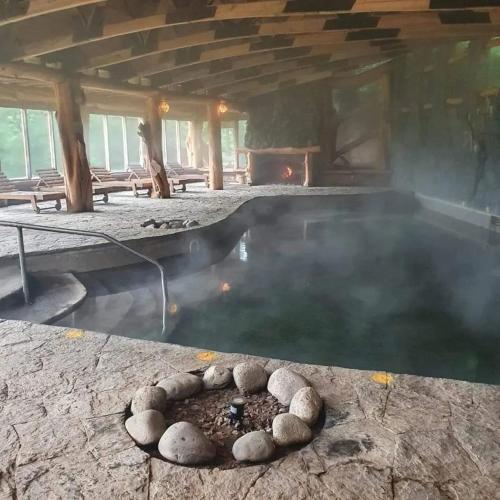 a pool of water with rocks in front of a fireplace at Hostal Mahuida in Pucón