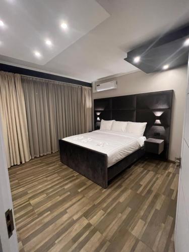 a bedroom with a bed and a wooden floor at Empire Apartments Su 1 Celinastraat in Paramaribo