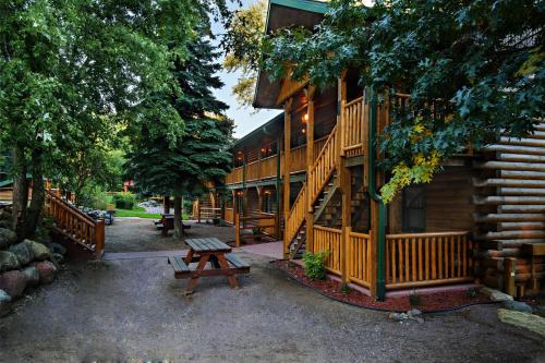 a wooden cabin with a picnic table in front of it at Meadowbrook Resort in Wisconsin Dells