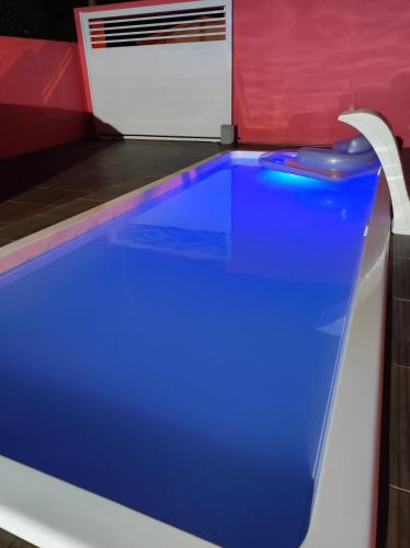 a blue pool in a room with a red wall at Pousada da Dinda - Casa Familiar in São Gabriel