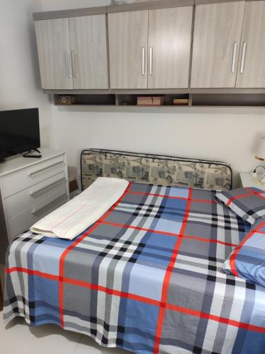 1 dormitorio con 1 cama con manta azul y roja en Pousada da Dinda - Casa Familiar, en São Gabriel