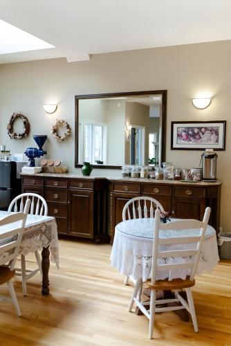 a dining room with a table and a mirror at Lady MacDonald Country Inn in Canmore