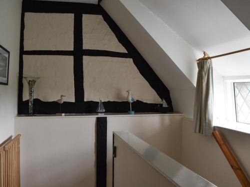 an attic room with a cross on the wall at Merryweather Cottage in Bembridge