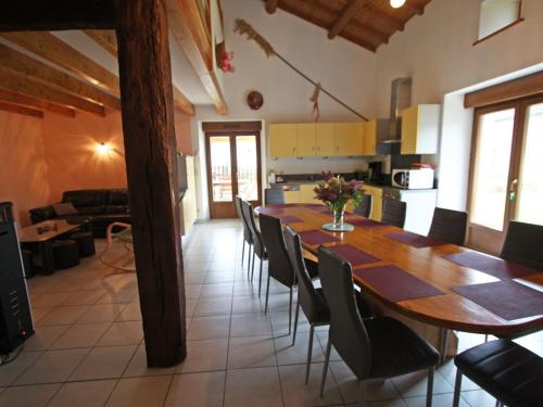 a kitchen and a dining room with a table and chairs at Gîte spacieux avec terrasse, confort moderne dans un cadre verdoyant et propice aux balades. - FR-1-589-79 in Bains-les-Bains