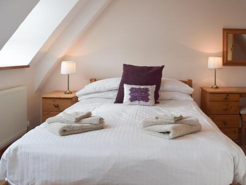 a bedroom with a white bed with towels on it at Sorrel - E4321 in Ludham
