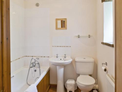 a bathroom with a toilet and a tub and a sink at Sorrel - E4321 in Ludham