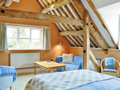 a bedroom with orange walls and a bed and a table at The Stable-e2836 in Whitminster