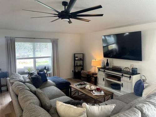 a living room with a couch and a flat screen tv at Riverside Riviera at Seminole Heights in Tampa