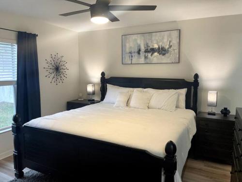 a bedroom with a large bed with a ceiling fan at Riverside Riviera at Seminole Heights in Tampa