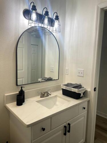 a bathroom with a sink and a mirror at Riverside Riviera at Seminole Heights in Tampa