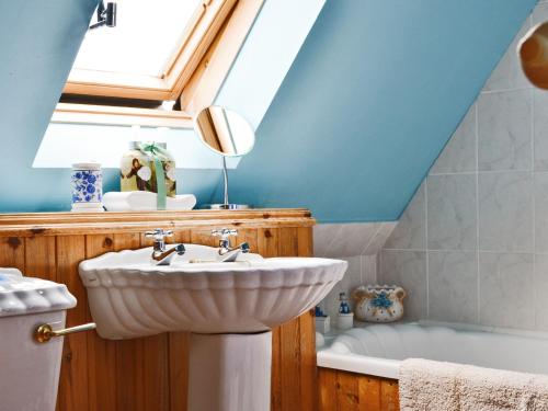 a bathroom with a sink and a bath tub at Rams Cottage in Glenelg