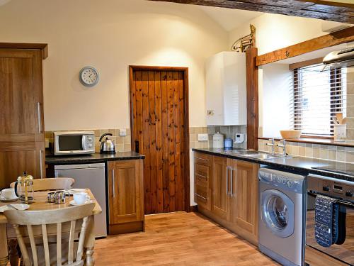 a kitchen with a washer and dryer in it at Pear Tree Cottage in Gillamoor