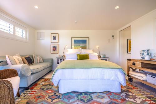 a bedroom with a bed and a couch at Relax on Newton in Oneroa