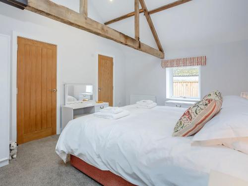 a white bedroom with a large bed and a window at Westfield Stables in Green Hammerton