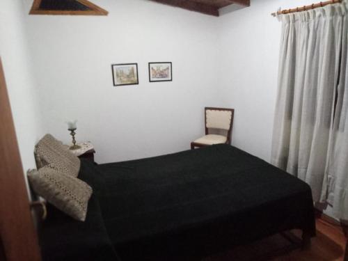 1 dormitorio con 1 cama negra y 1 silla en DUPLEX BARRIO CONSTITUCIÓN A 6 CUADRAS DE LA PLAYA en Mar del Plata