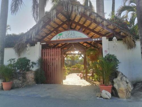 een toegang tot een gebouw met een bord dat leestekens bevat bij Las Palmas Eco Residence in Las Terrenas