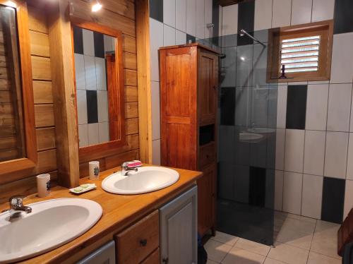 y baño con 2 lavabos y ducha. en LE TRI HAUT DE BELLEVUE - Bungalow Colibri, en Pointe-Noire