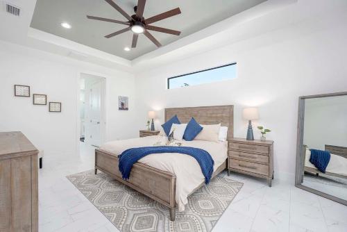 1 dormitorio con 1 cama grande y ventilador de techo en Brand New Home! On Intersecting Canals, Pool, Sleeps 8 - Villa SeaDuction, en Cabo Coral