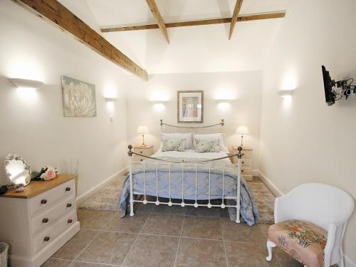 a bedroom with a bed and a dresser and a chair at Beacon Cottage - E5463 in Wainfleet All Saints